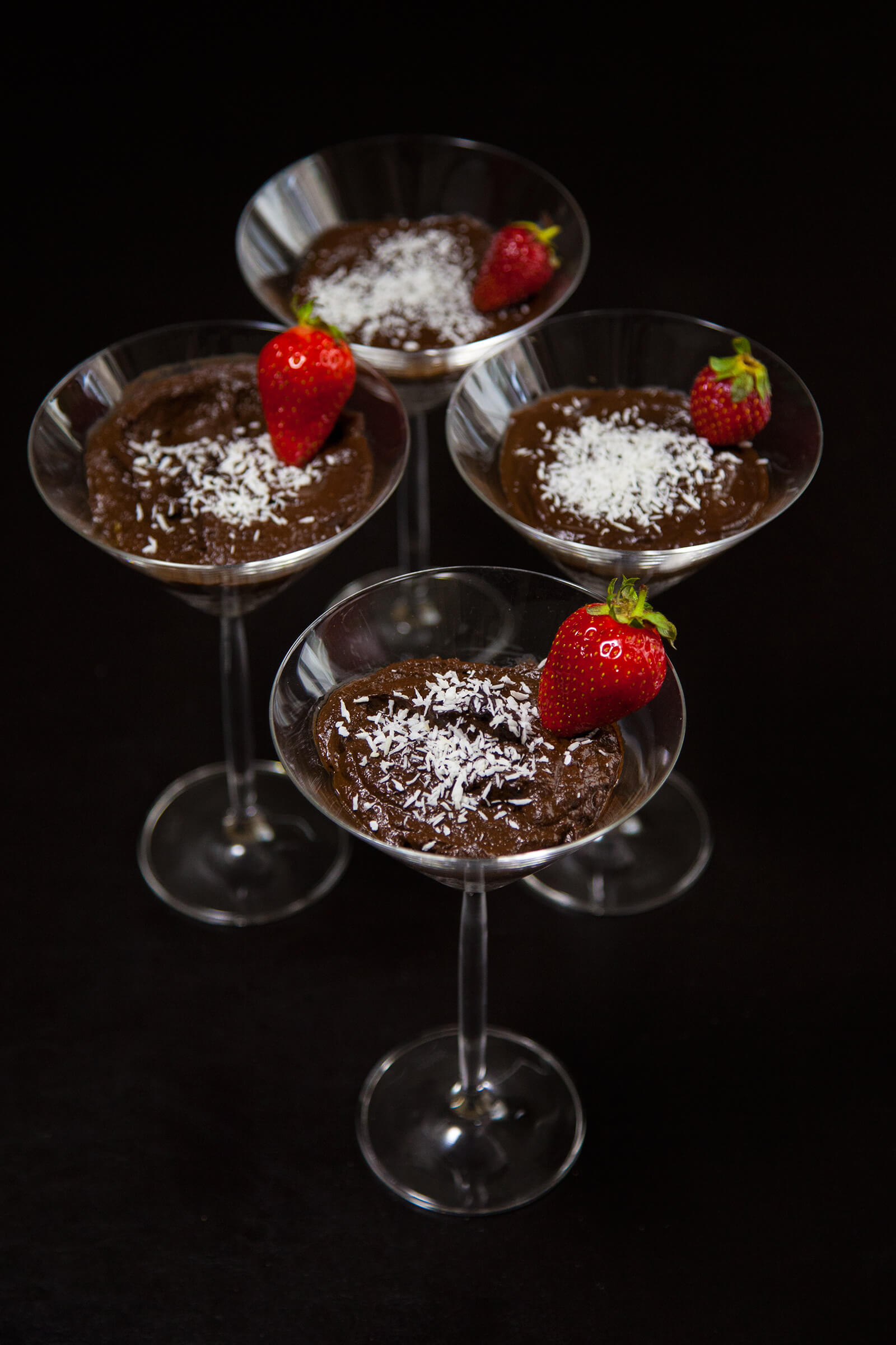 Four servings of healthy chocolate mousse in martini glasses